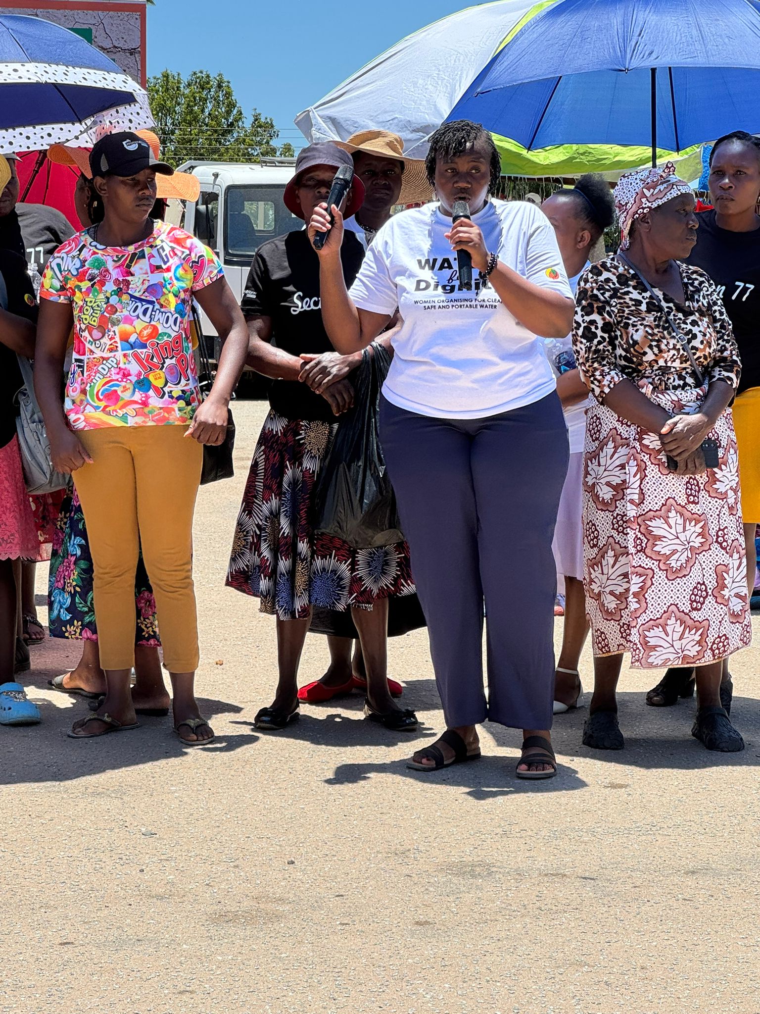 Woman speaking at Women4Water protest with Young Women in Leadership supporters