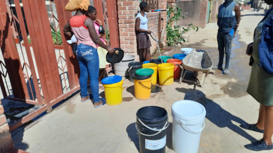Women collecting water with buckets